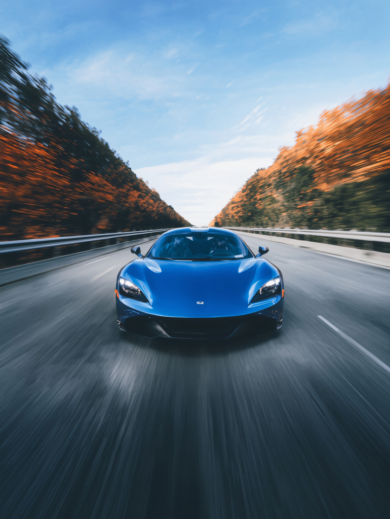 Red sports car on the road at sunset